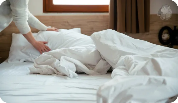 kobieta ścieląca łóżko o poranku